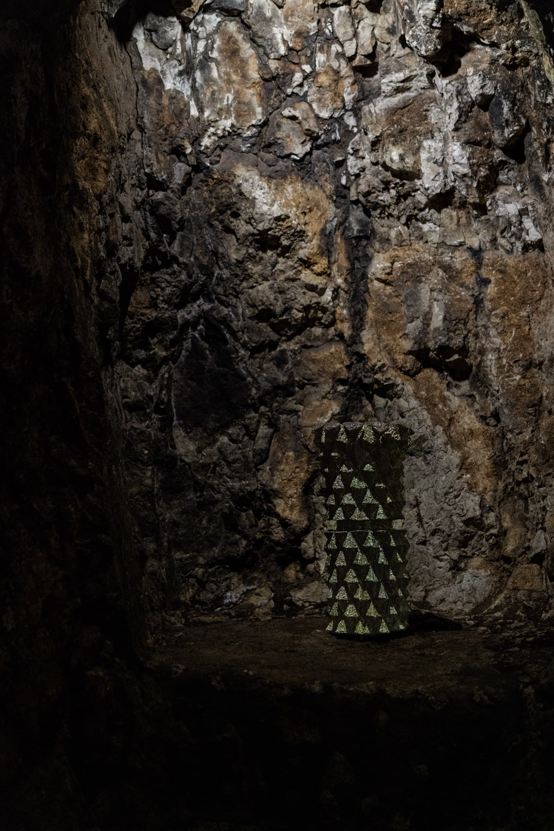 Scultura ibrida di Meletios Meletiou, dalla superficie come bagnata, fusa con la roccia della grotta.