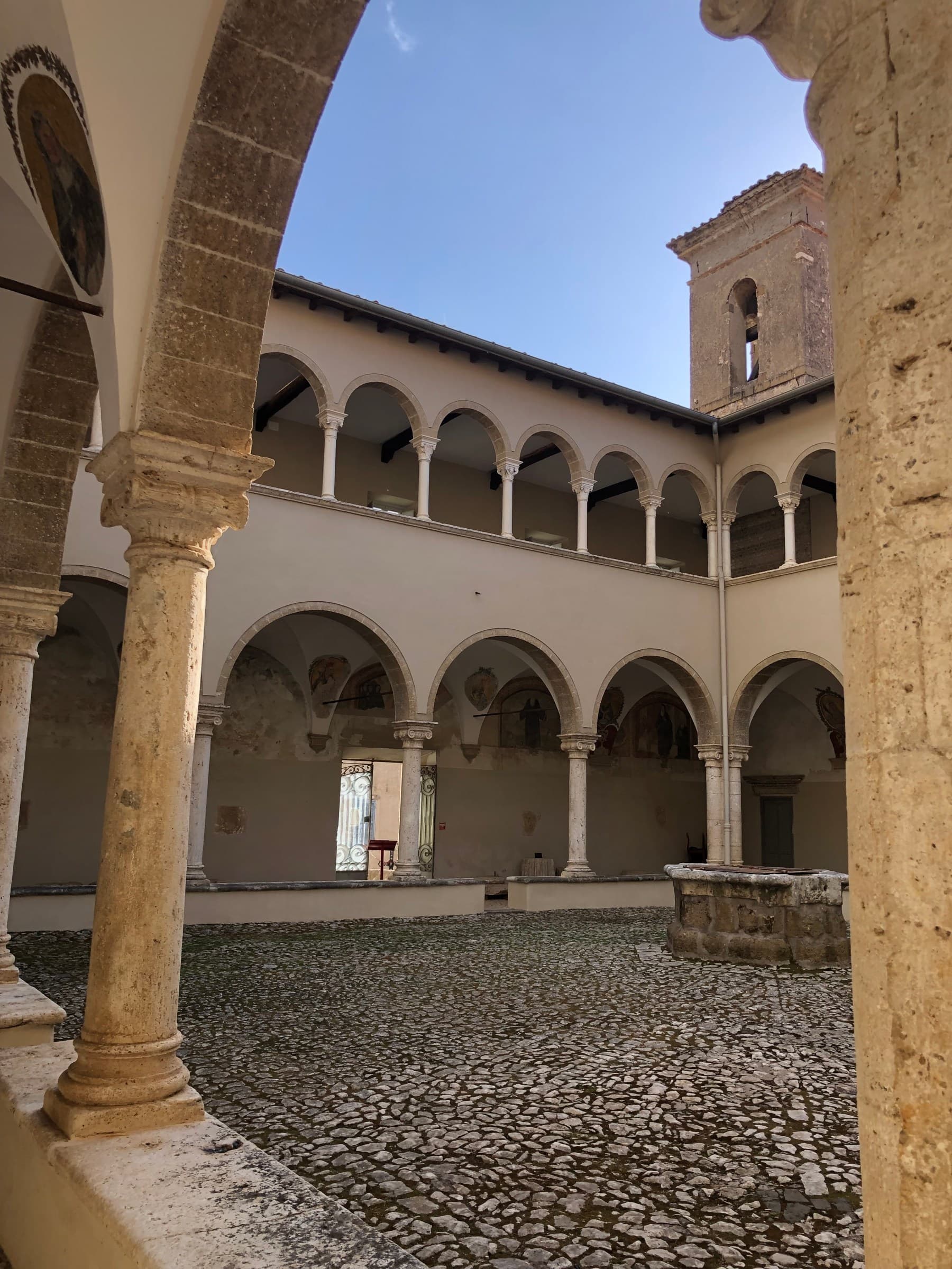 Il chiostro del Complesso Monumentale di Sant'Oliva, con le arcate e il campanile contro il cielo.