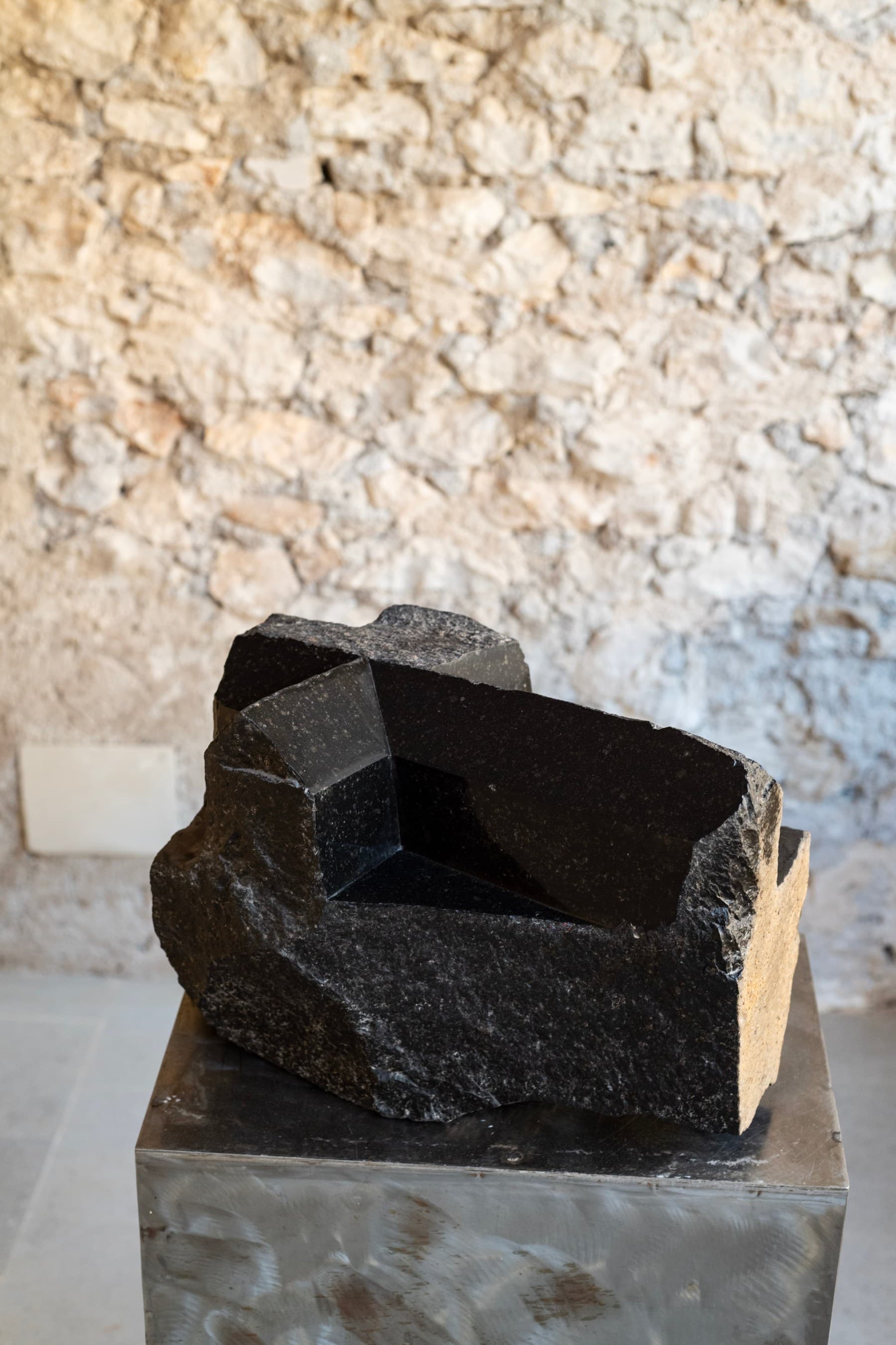 L'opera in granito nero Ort di Graziano Pompili su piedistallo in acciaio specchiato, nella loggia.